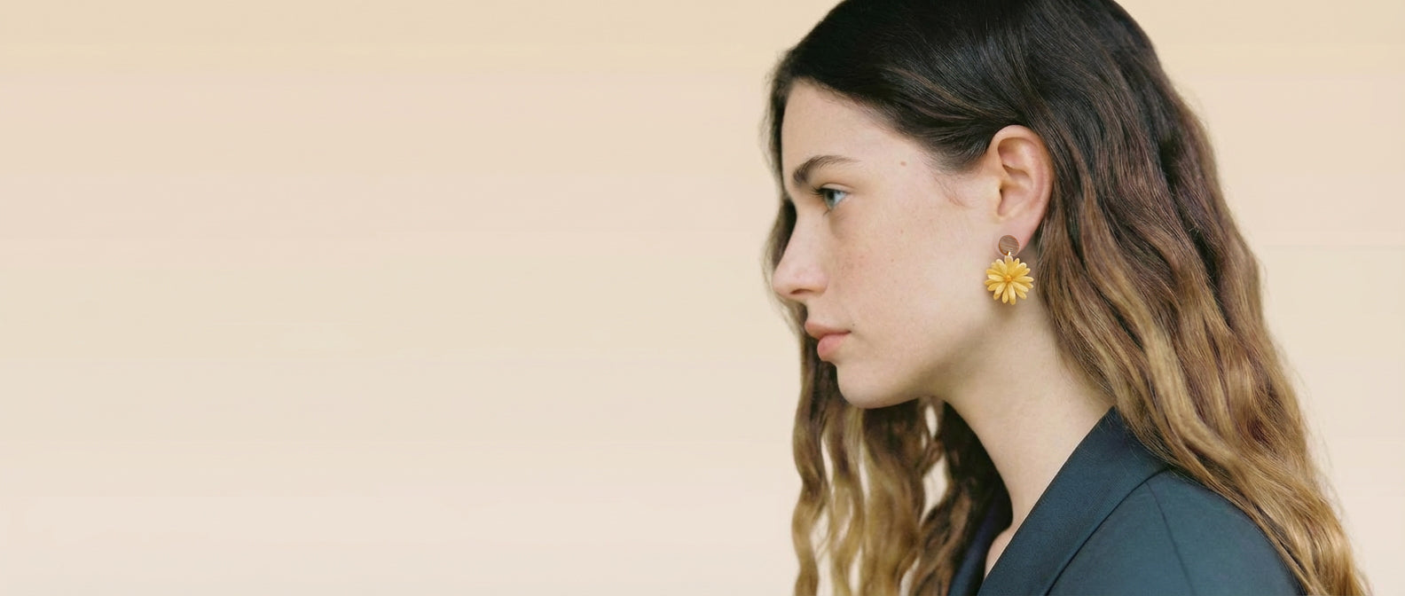 Model wearing handcrafted jewelry inspired by traditional craftsmanship and natural materials
